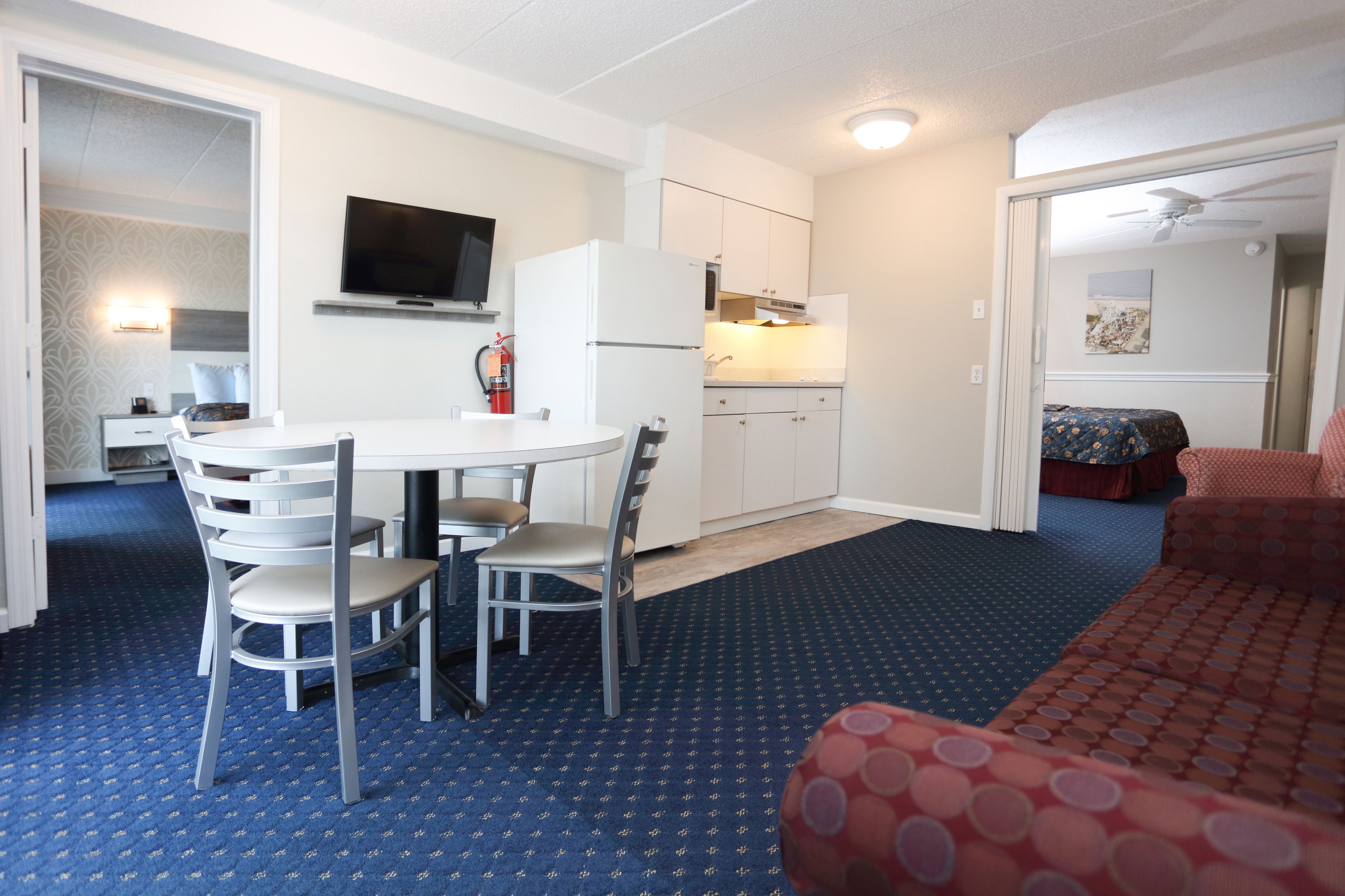 Une chambre d’hôtel compacte comprenant un coin repas, une kitchenette et un lit.