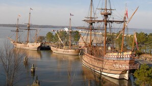 Three historic sailing ships docked at a marina with clear skies. - Anvil Campground (Williamsburg)