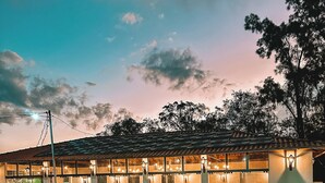 A building with a tiled roof, large windows, and outdoor seating. - Hotel Pontal de Tiradentes (Tiradentes)