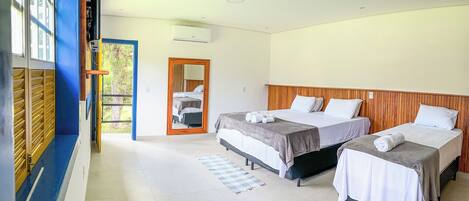 A hotel room with two beds, a large mirror, and a view of the outside.
