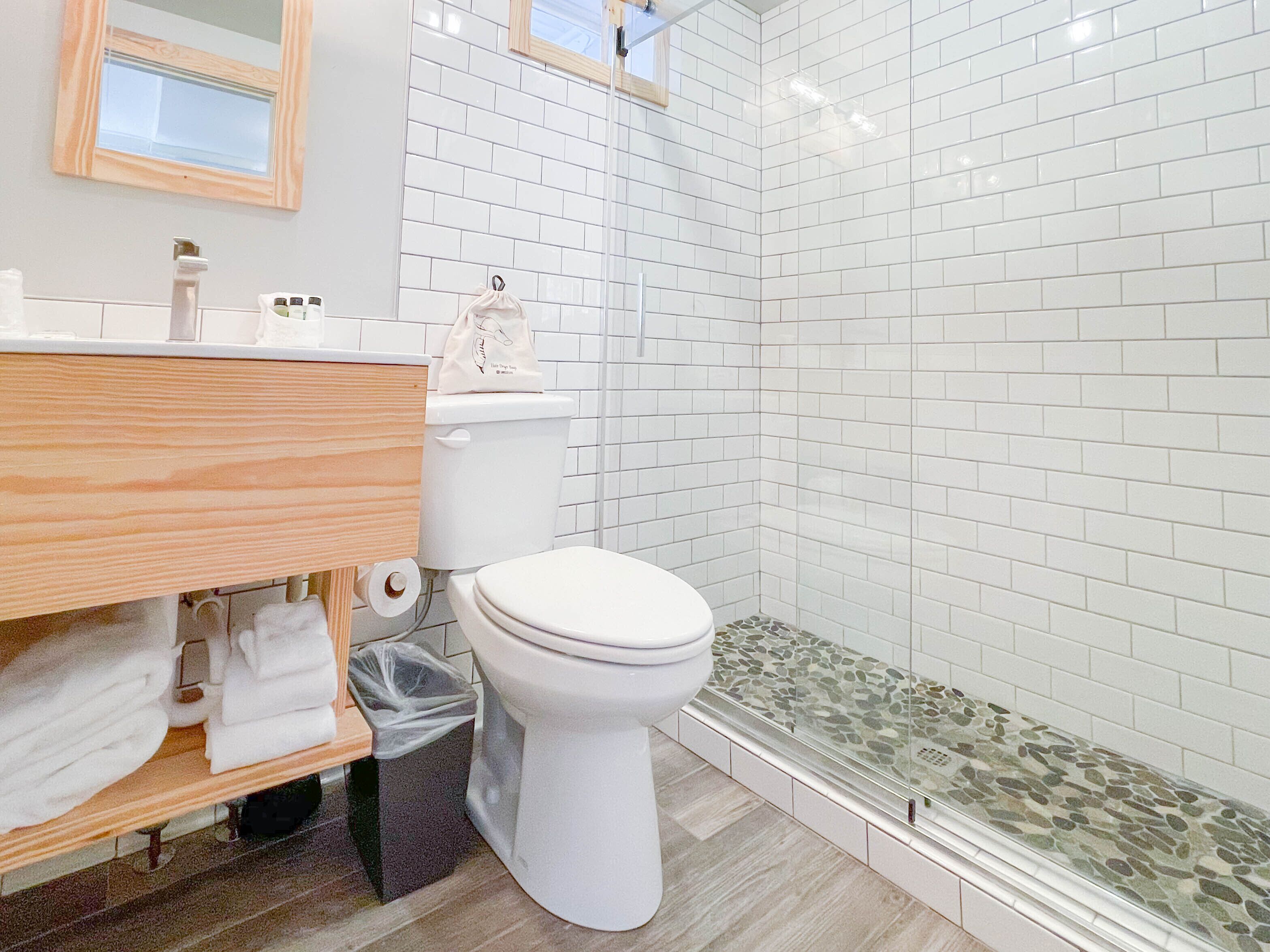 A bathroom with a toilet, sink, and shower area.