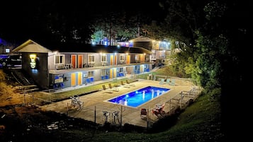 Una piscina al aire libre de temporada, sillones reclinables de piscina
