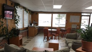 Un restaurante con pared de ladrillo, muebles de madera y ventanas amplias.