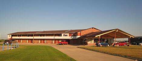 A motel with a central building and a covered parking area.