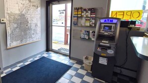 An indoor area with a map on the wall, an ATM, and a door leading outside. - Capital O Swan Inn Comstock Park (Comstock Park)