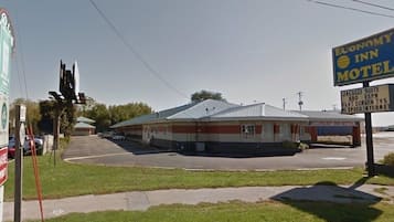 A motel with a sign advertising amenities like a Jacuzzi suite, HBO, ESPN, flat-screen TVs, and high-speed internet.