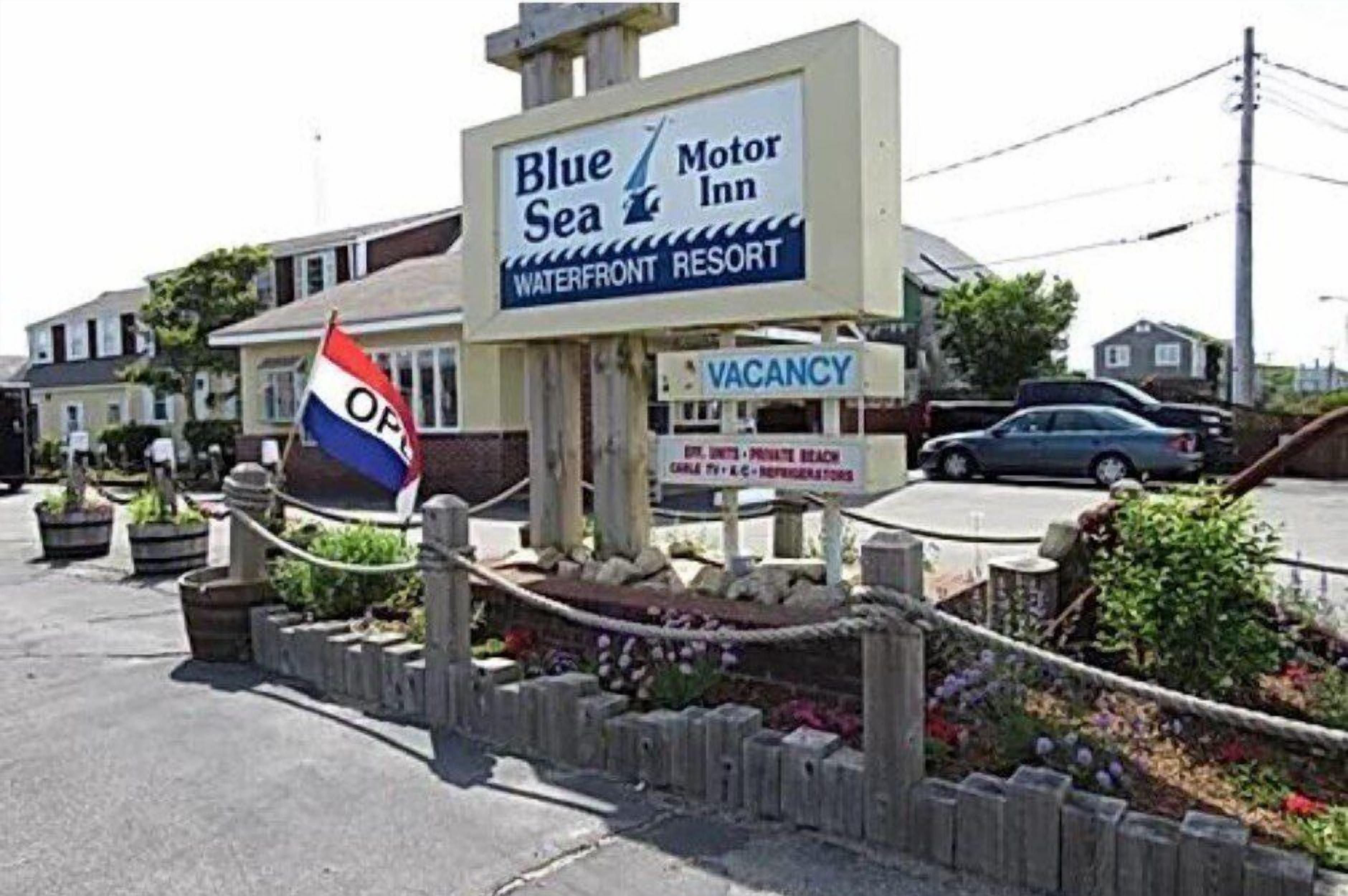 A Blue Motor Inn sign with a vacancy notice and a flag.