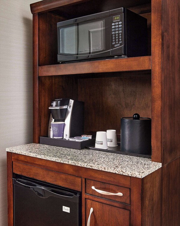 A compact kitchenette with a microwave, coffee maker, and storage for mugs and a kettle. - Hilton Garden Inn Nashville Downtown/Convention Center (Nashville)