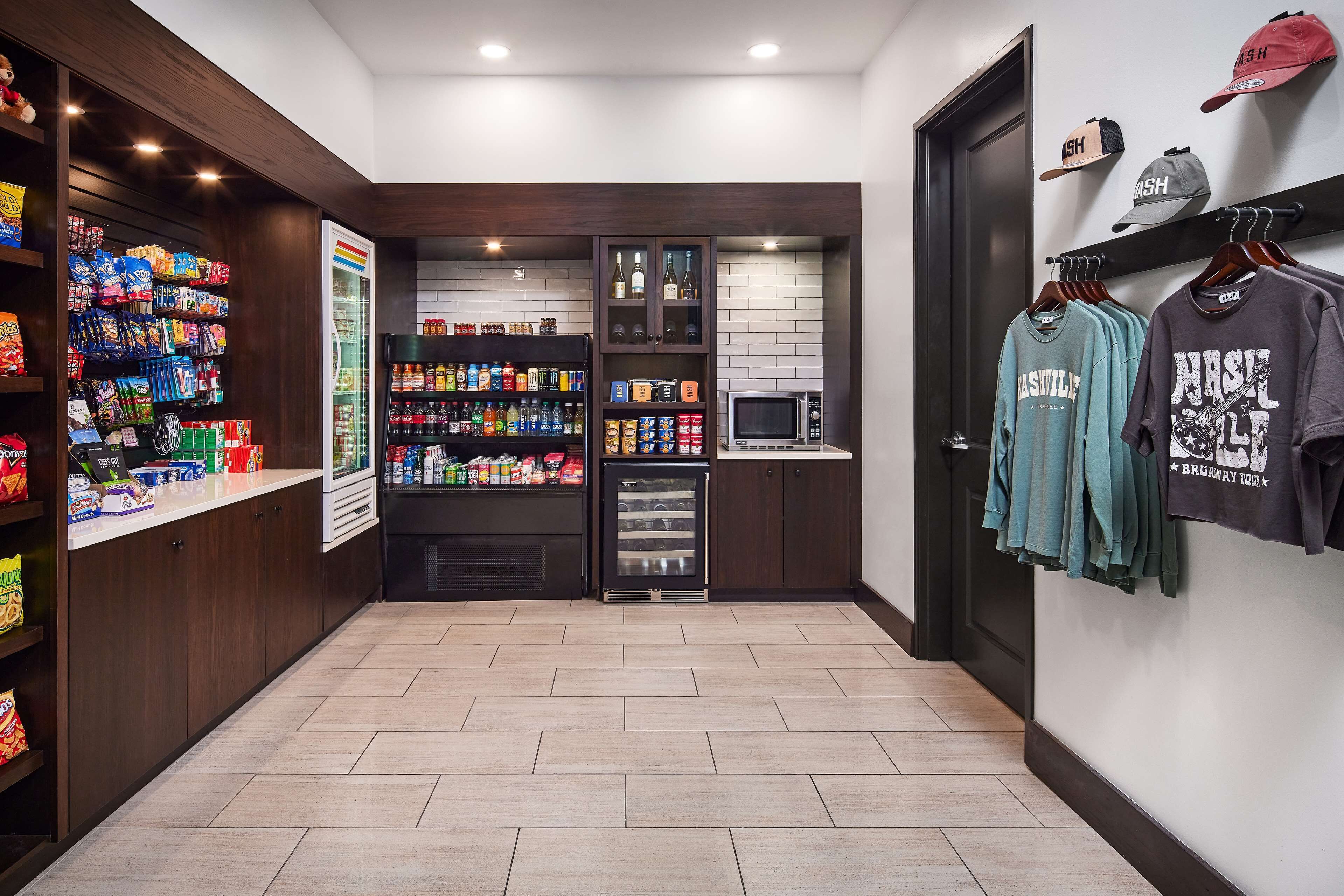 A hallway with snack shelves, a beverage refrigerator, and a microwave.