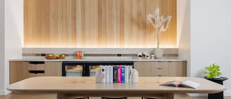 A modern kitchen with wooden cabinets, a granite countertop, and a dining area with a wooden table and chairs.