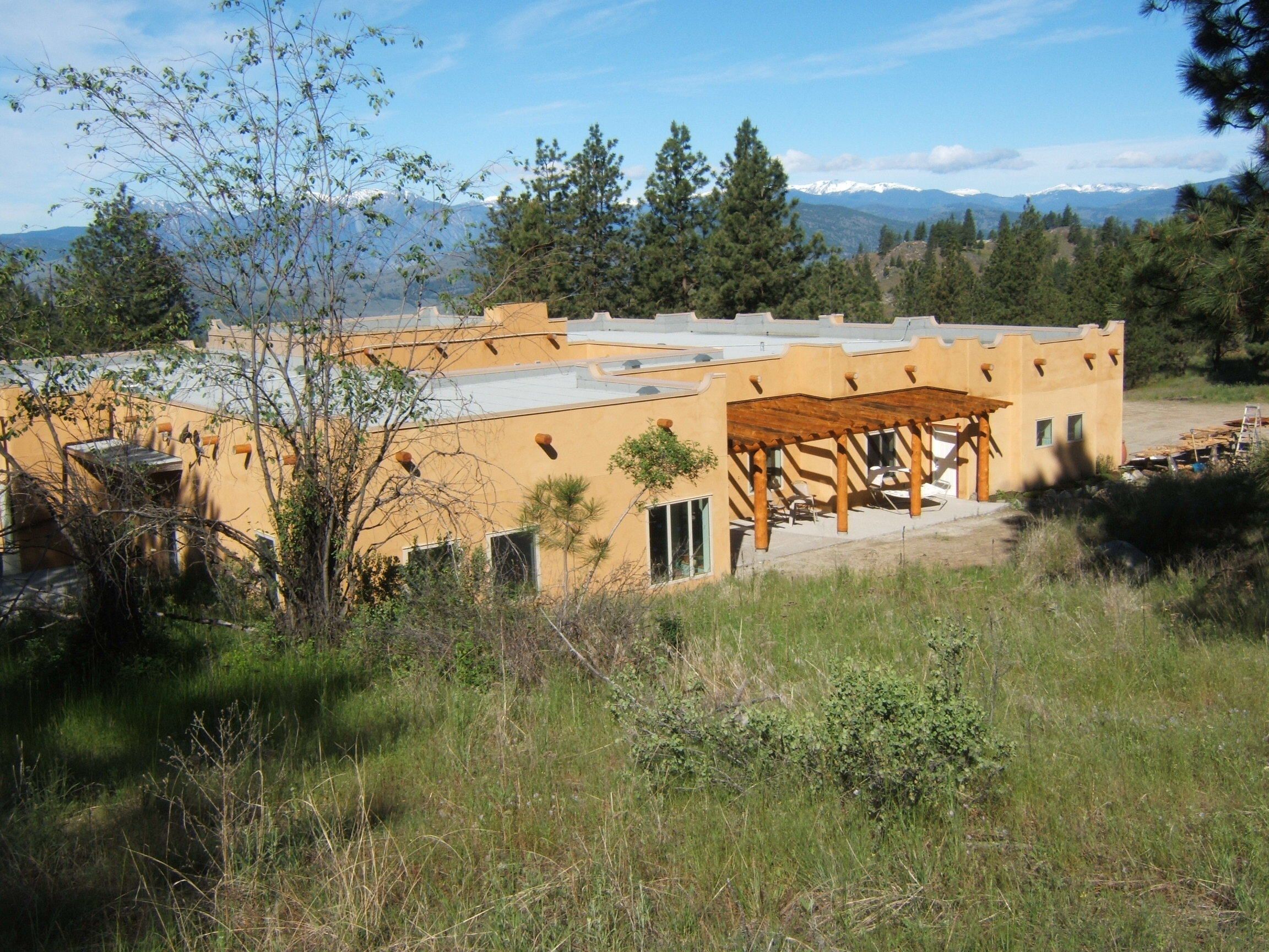 A modern building with a flat roof and a covered patio area.