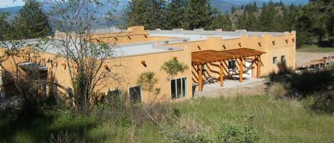 A modern building with a flat roof and a covered patio area.