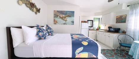 Un dormitorio con cama, escritorio y kitchenette.