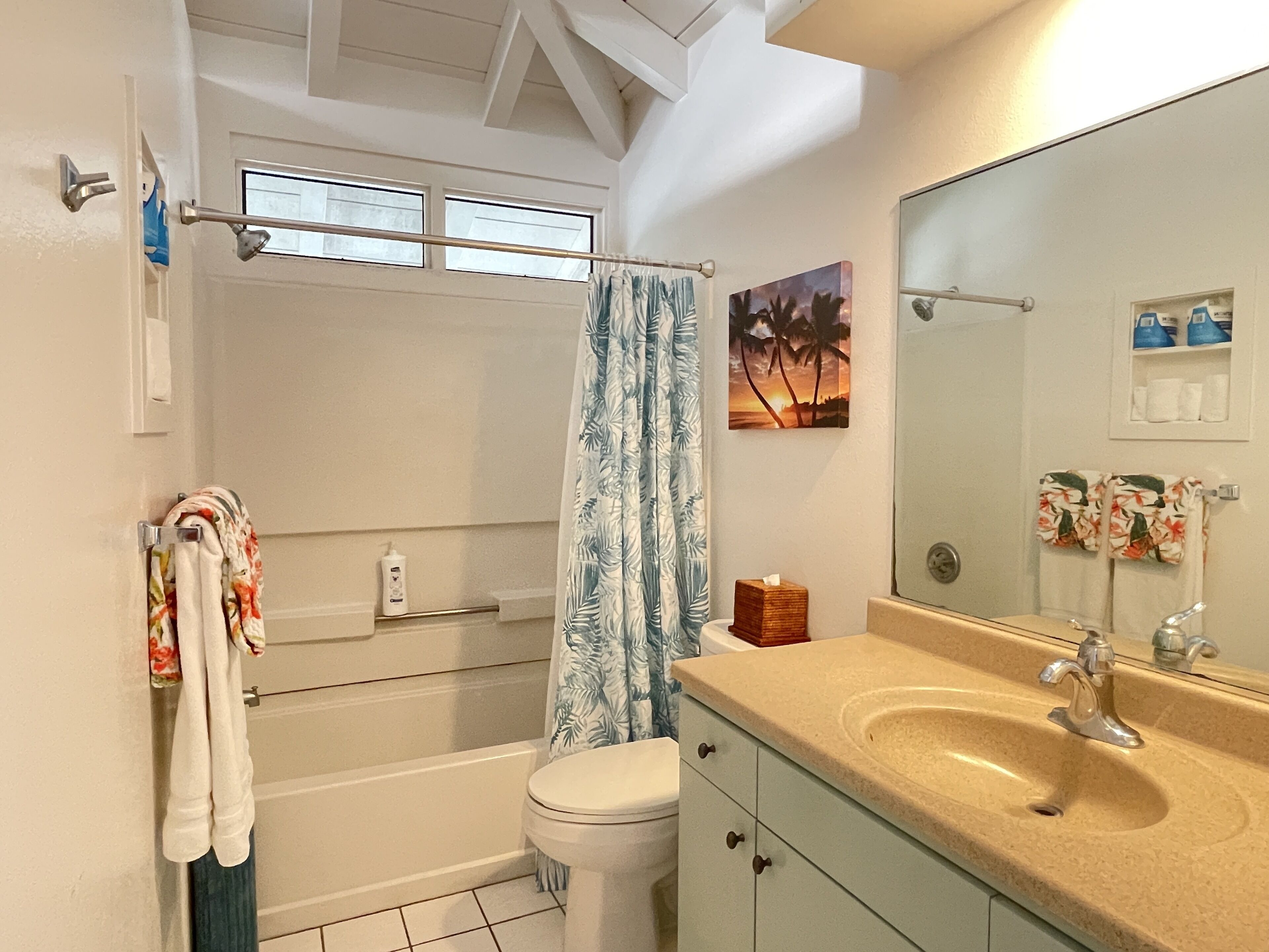 Une salle de bain avec une baignoire, des toilettes, un lavabo et un grand miroir.
