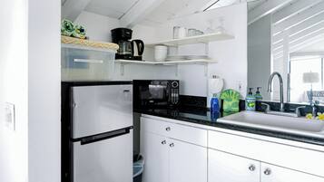 Eine moderne Küche mit einem Edelstahl-Kühlschrank, einer Mikrowelle und einer Kaffeemaschine auf der Arbeitsplatte.