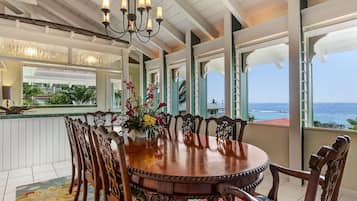Enjoy meals in this elegant dining area with a round table, ornate chairs, and a chandelier.