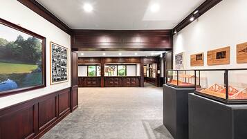 A spacious lobby with wooden paneling, framed photographs, and display cases.