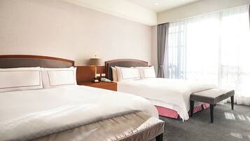 A hotel room with two beds, a nightstand with a lamp, and a large window with curtains.