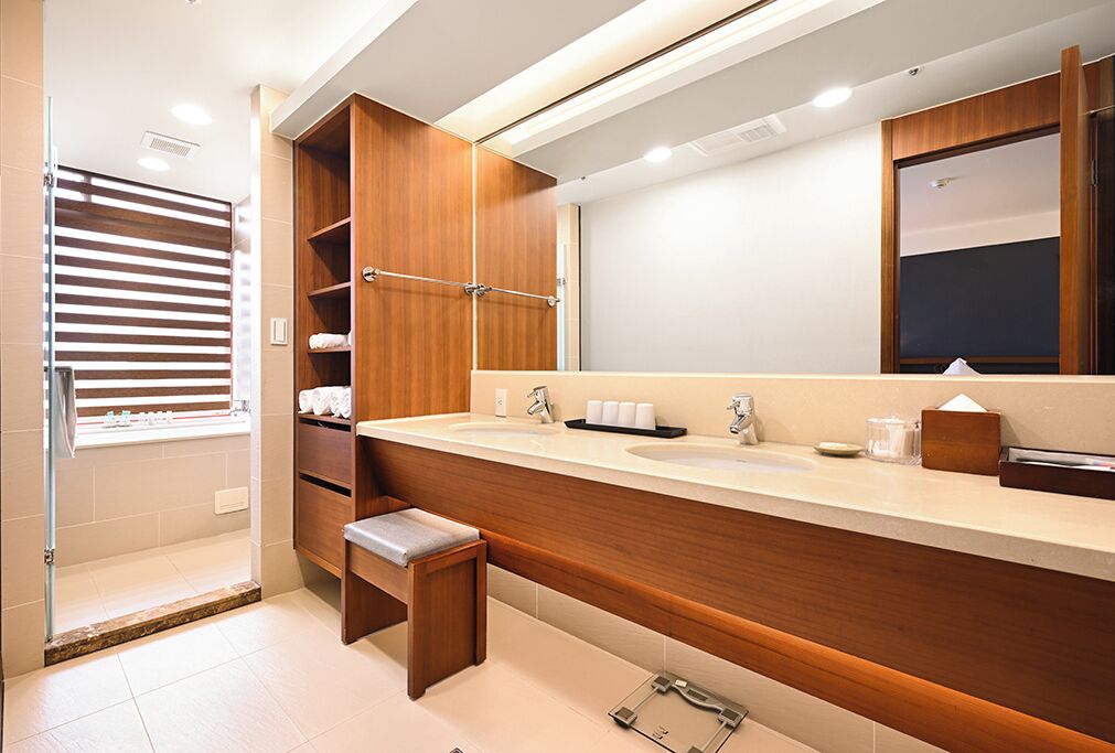 A modern bathroom with a wooden vanity, two sinks, and a large mirror.