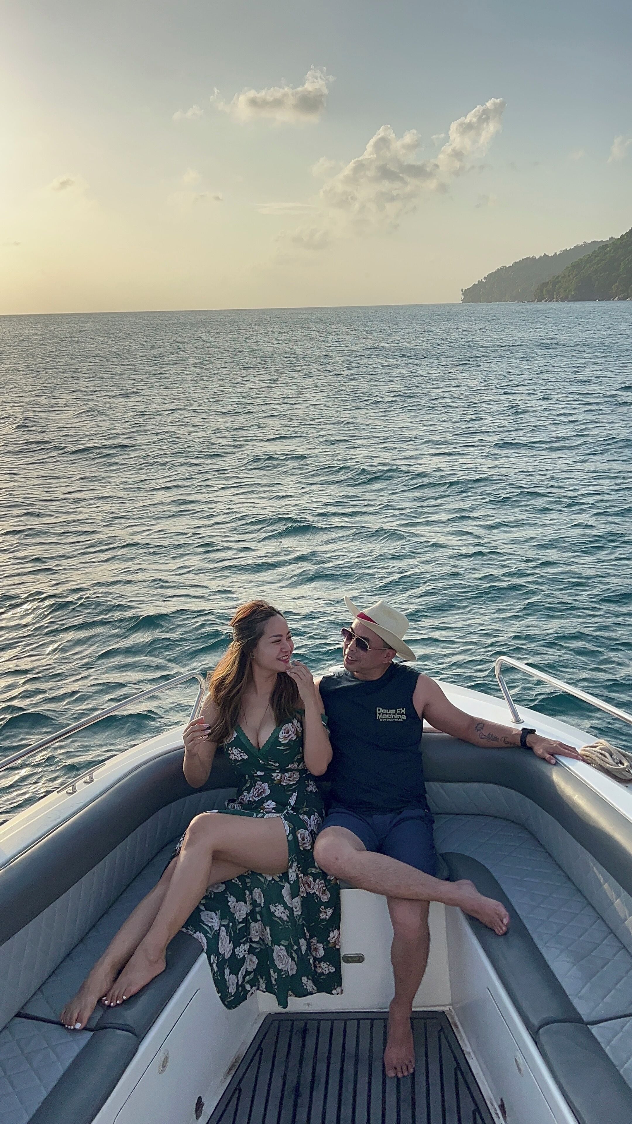 Deux personnes se trouvent sur un bateau, d’où l’on peut admirer la mer et une côte lointaine.