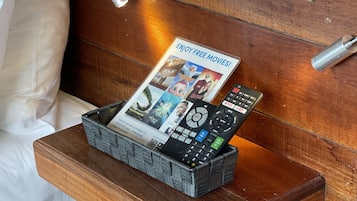 Een houten nachtkastje met een afstandsbediening en een tijdschrift erop.