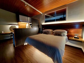 Ein modernes Schlafzimmer mit einem großen Bett, einem Schreibtisch und einem Spiegel.