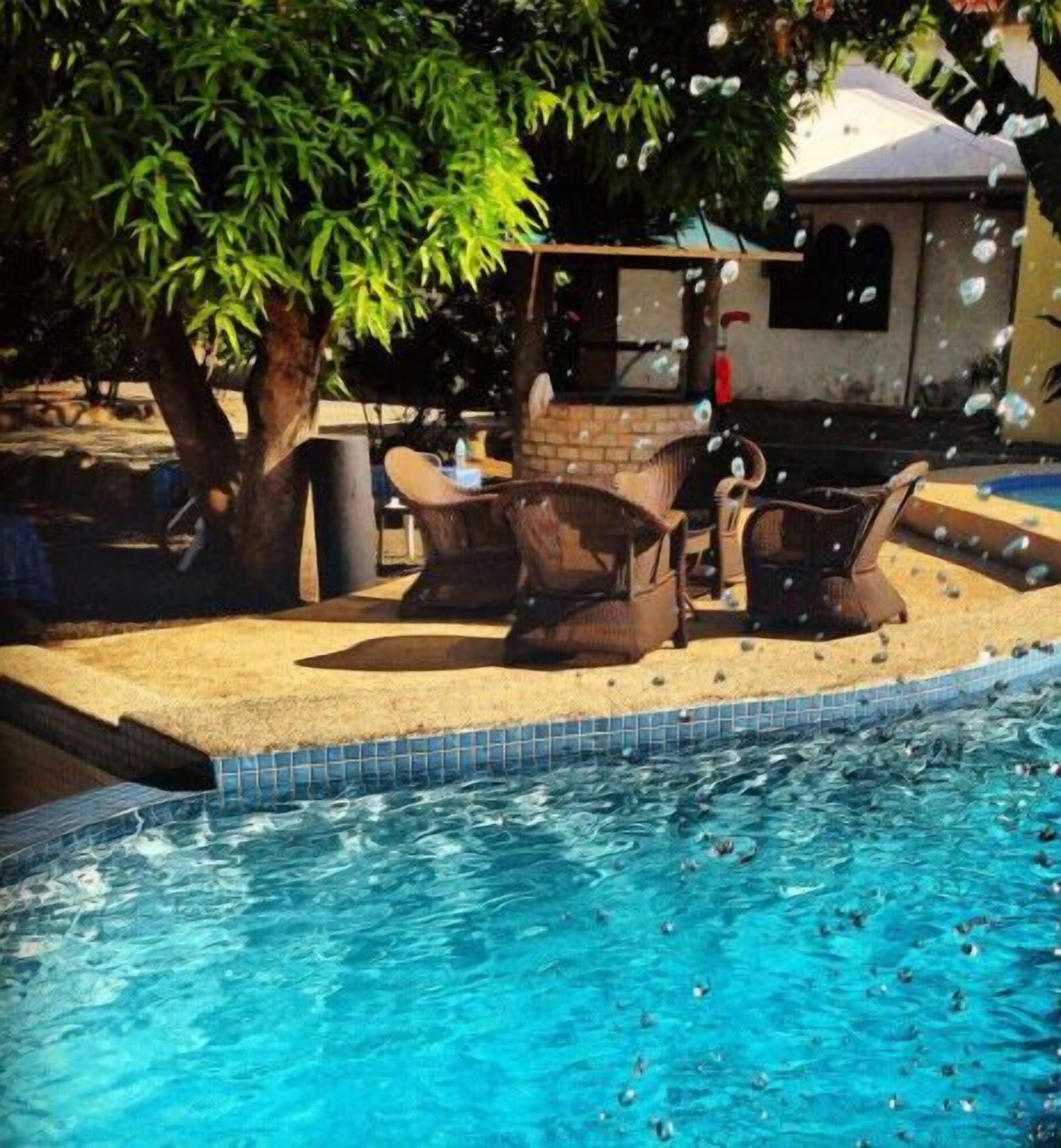 A swimming pool with lounge chairs and a barbecue area.
