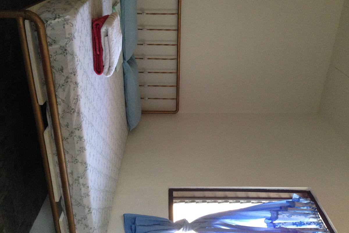 A bunk bed with a floral-patterned mattress and a blue pillow.