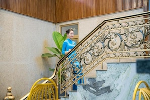 A staircase with ornate metal railings and a person ascending. - Platinum Beach Hotel (Da Nang)
