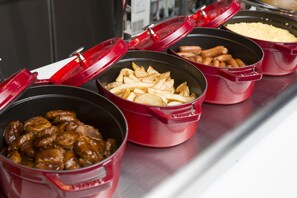 Ein Buffet mit verschiedenen Speisen in roten Behältern.