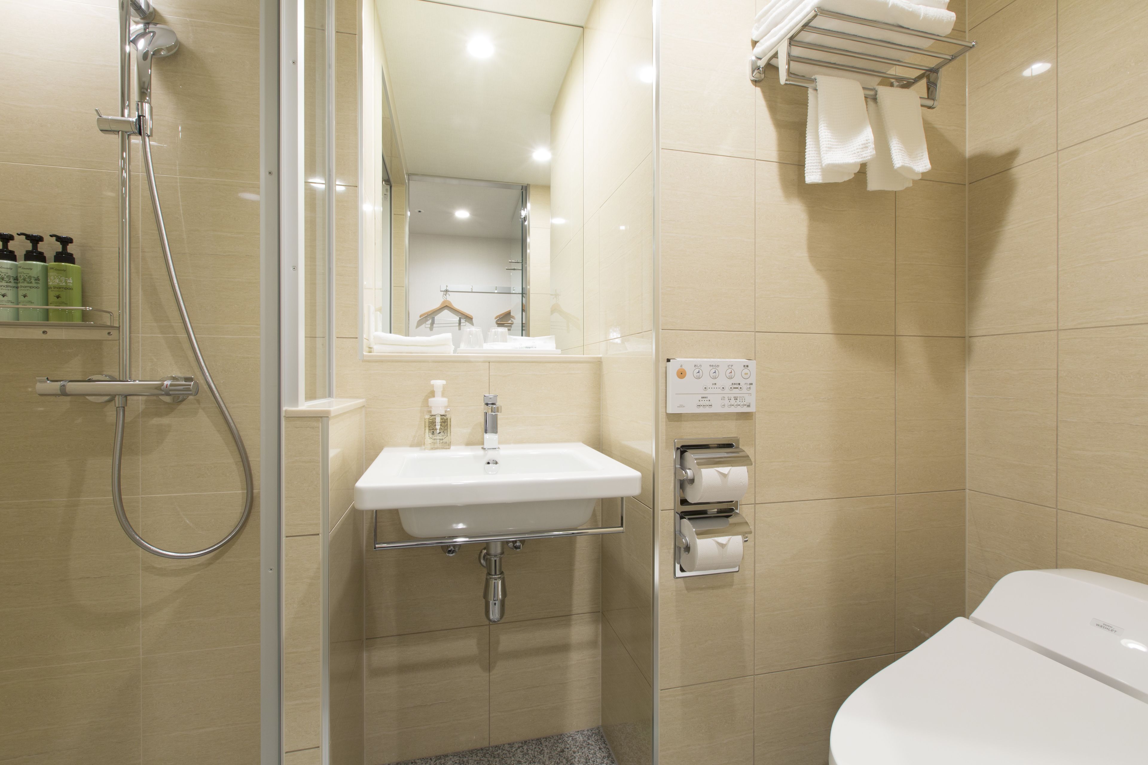 A modern bathroom with a shower, sink, and toilet.