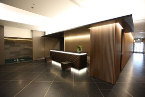 Ein Empfangsbereich im modernen Design mit einer Rezeption, einer Lounge und einer Pflanze.
