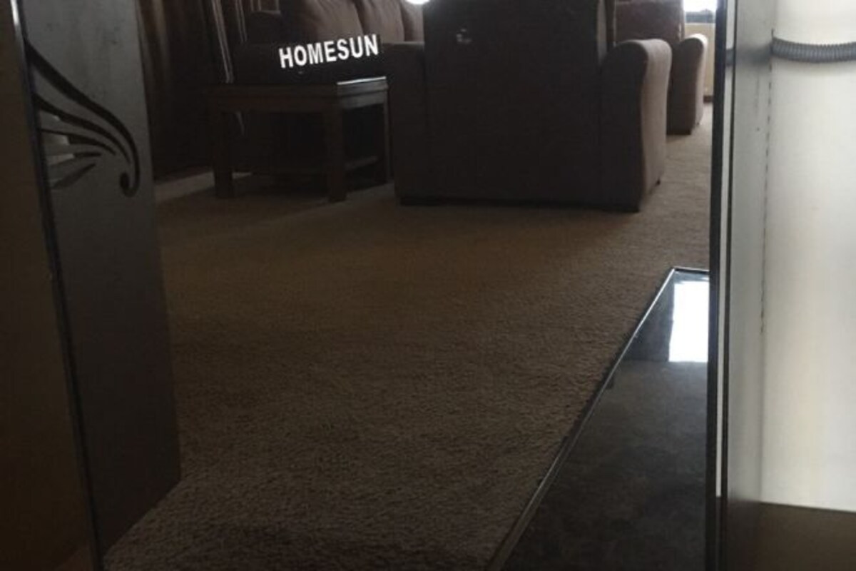A carpeted living room with a dark-colored sofa and a small table.