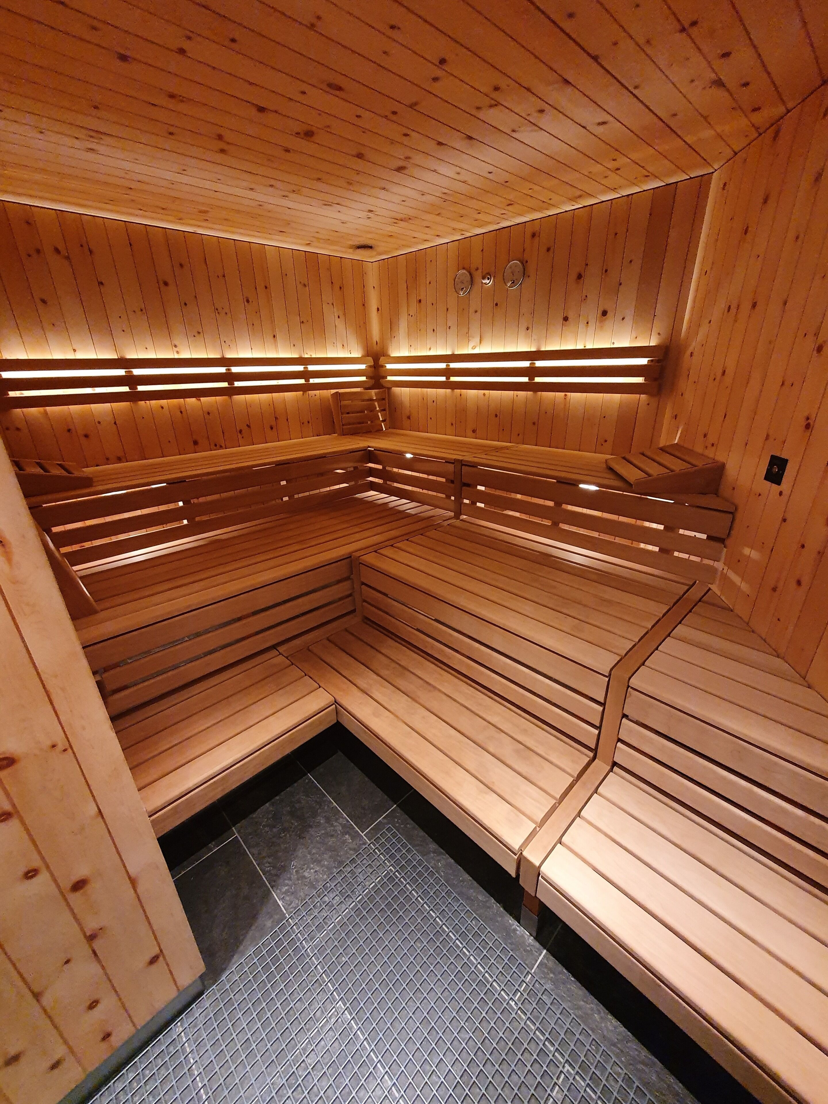 A sauna with wooden benches and a tiled floor.