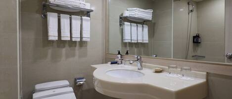 Une salle de bain moderne équipée de toilettes, d’un lavabo et d’une douche.