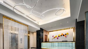 A modern lobby with a reception desk, a decorative wall with circular patterns, and a large glass partition. - K Hotel - Taipei II (Taipei)