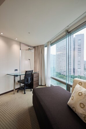 A hotel room with a bed, a desk, a chair, a large window, and a view of buildings. - K Hotels Dunnan (Taipei)