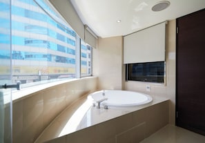 A modern bathroom with a large bathtub, a window with a view of a building, and a dark door. - K HOTEL - Yunghe (New Taipei City)