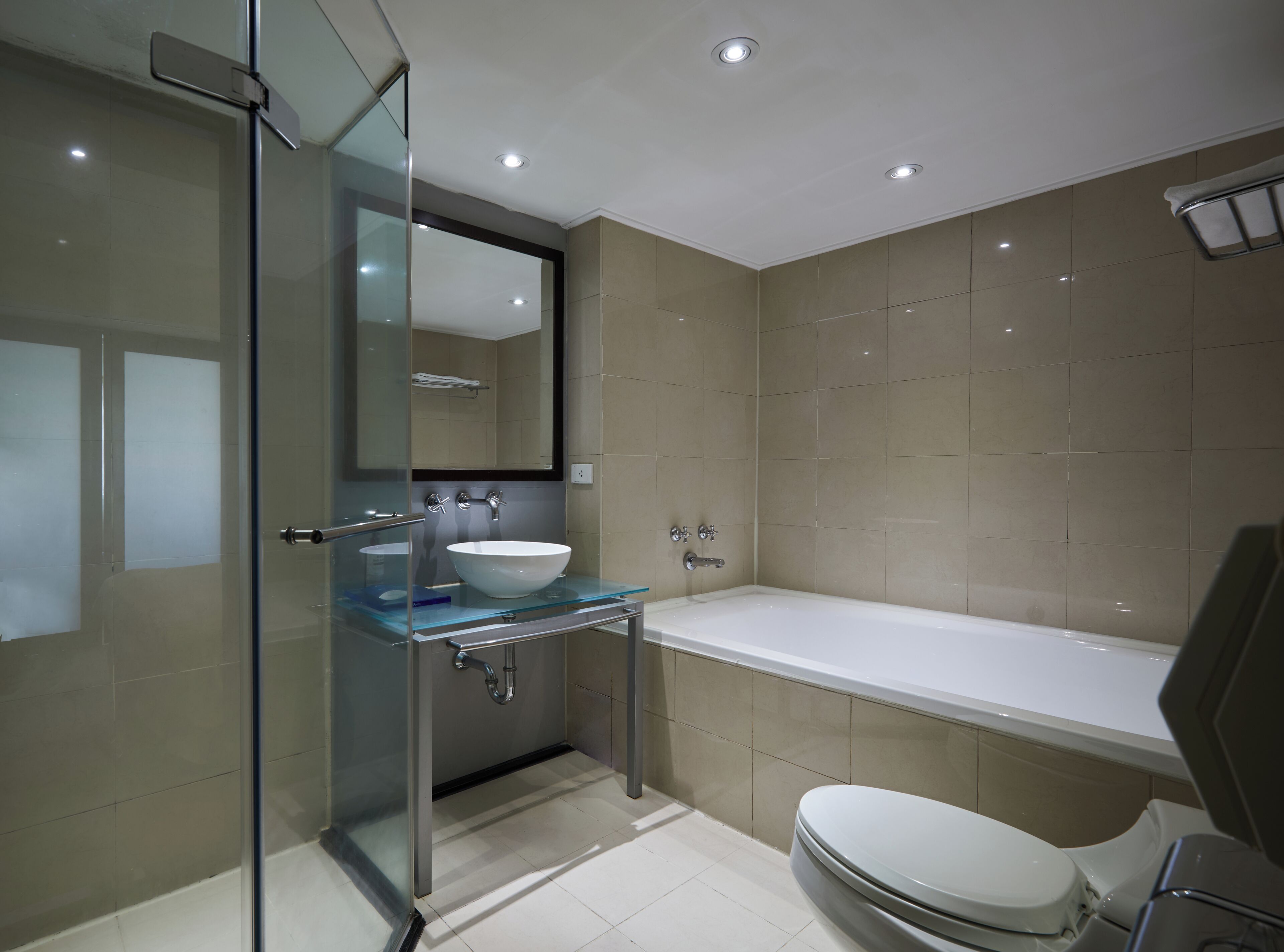 Une salle de bain moderne avec une douche à parois de verre, un lavabo blanc, une baignoire et des toilettes.