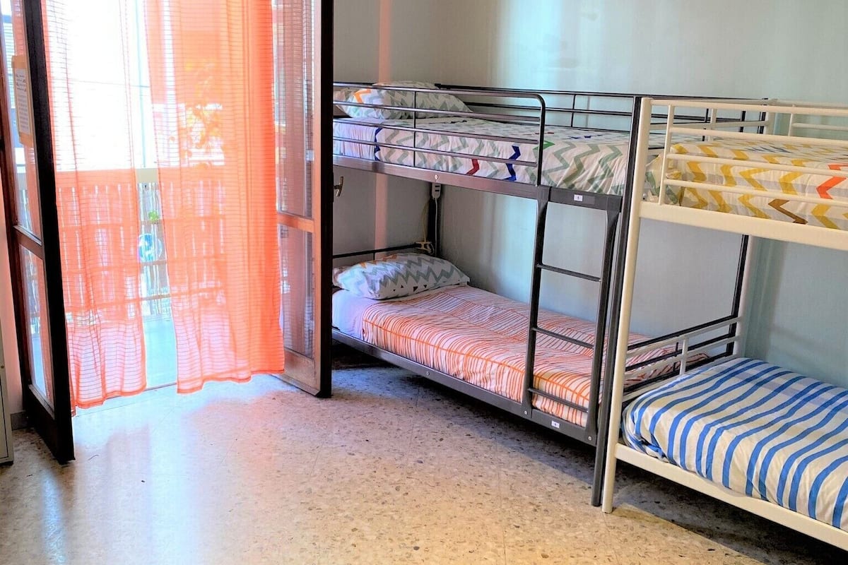 Dormitorio con literas, ventana y puerta.