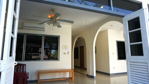A clean, modern interior with a ceiling fan, a bench, and a hallway leading to an arched doorway. - Baan Suksabai Hua Hin (Hua Hin)