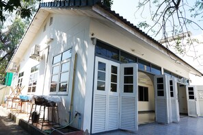 A building with a white facade, large windows, and a tiled roof.