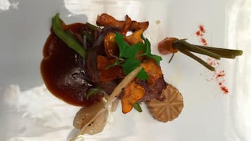 Un plato blanco con un guiso de carne, verduras y salsa.