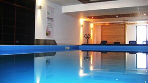 Une piscine avec un bord bleu, une banderole accrochée au mur et un mur en bois en arrière-plan.