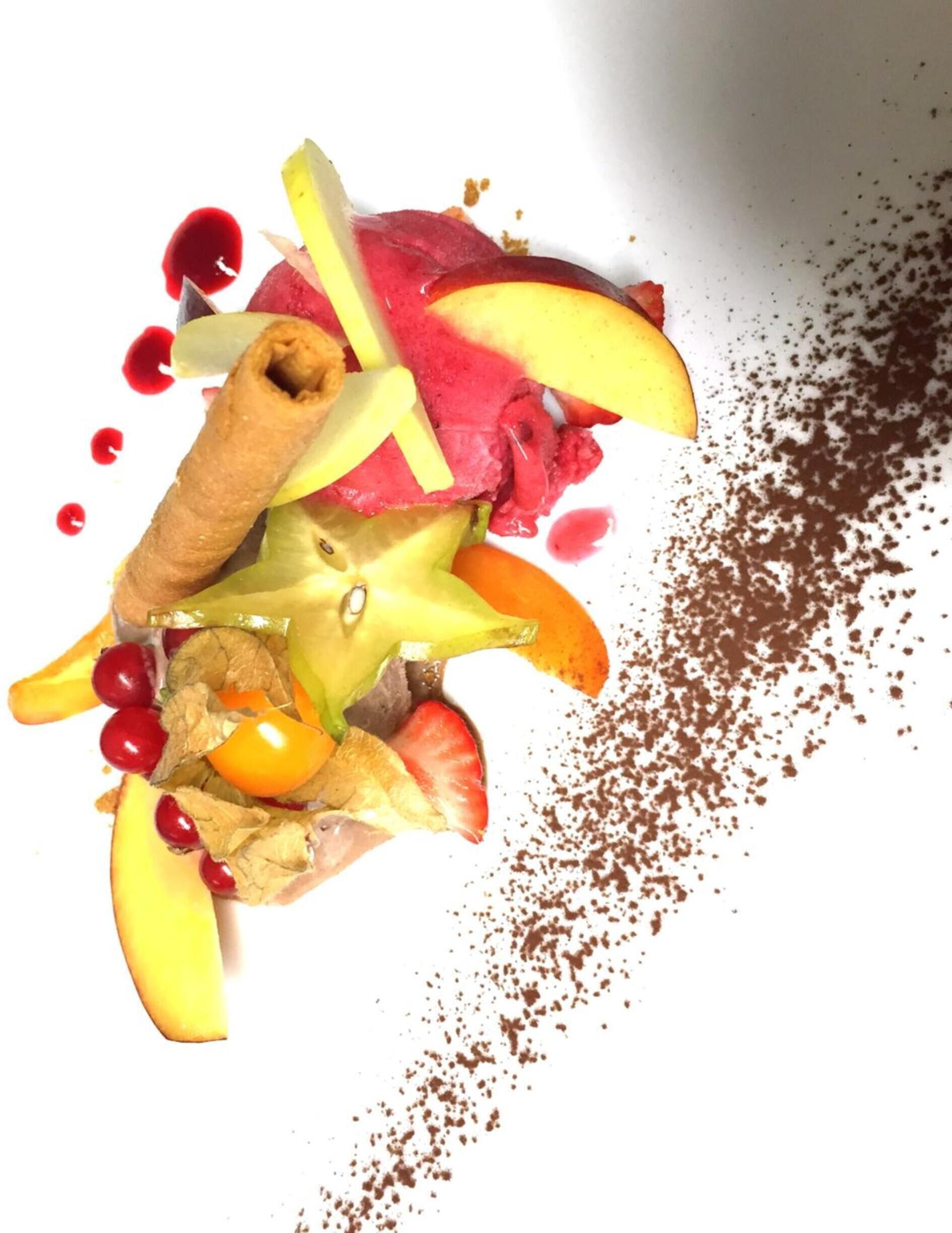 Un postre con diversas frutas y espolvoreado de chocolate.