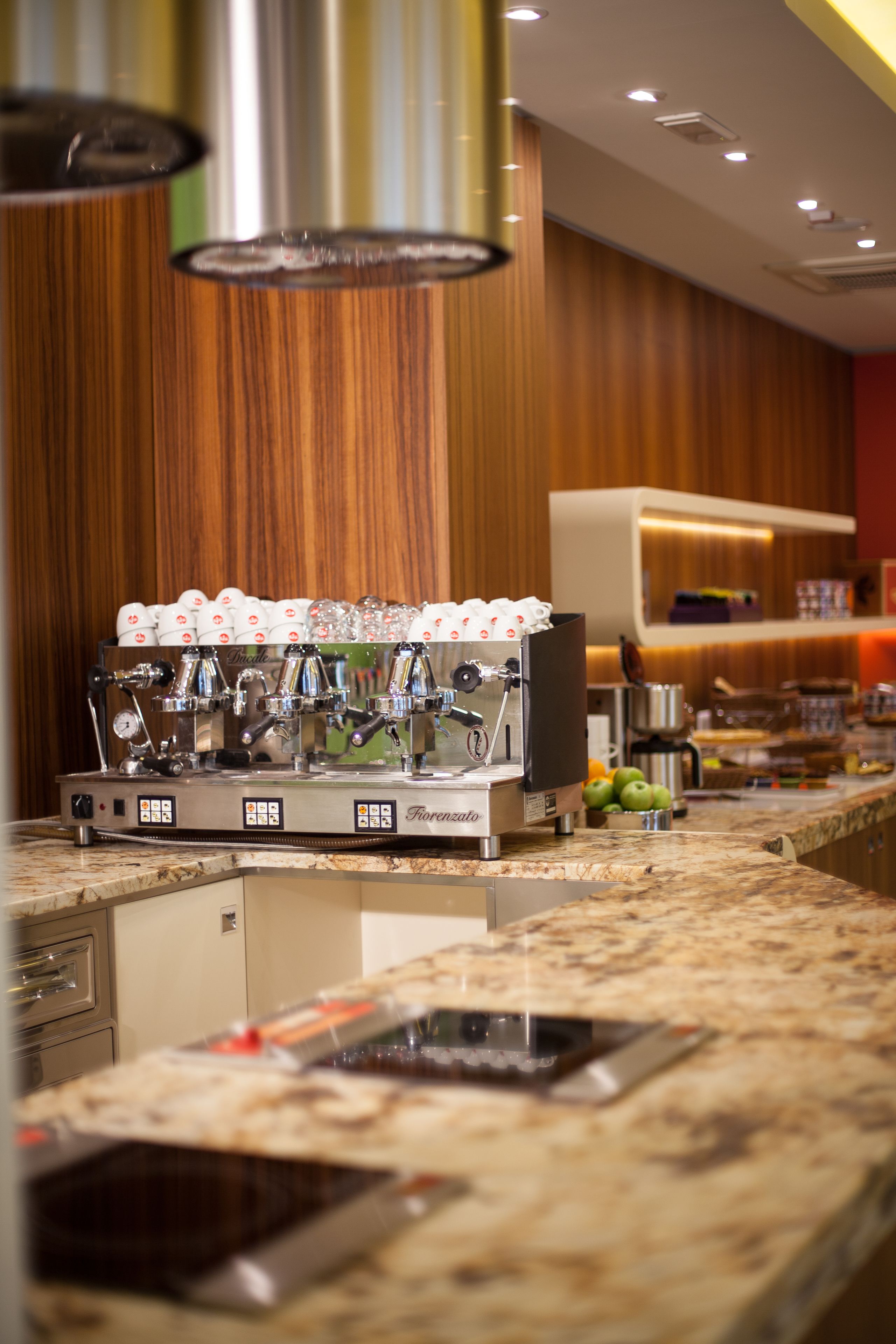A coffee machine with multiple dispensers, a stainless steel espresso machine, and a coffee cup holder.