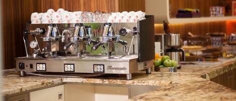 A coffee machine with multiple dispensers, a stainless steel espresso machine, and a coffee cup holder.