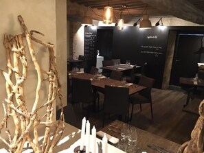 A restaurant interior with rustic decor, including a branch sculpture and candlelit tables. - Ici M'aime Hôtel Restaurant (Rouvray)