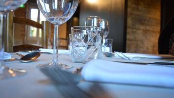 A dining table set with clear glassware and cutlery, indicating a formal dining setting.