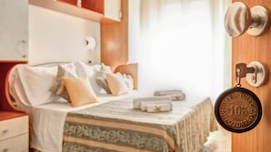 Une chambre d’hôtel comprenant un lit, une table de chevet, une armoire et une porte dotée d’un système de verrouillage à carte magnétique.